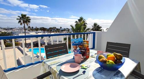 a table with a bowl of fruit on a balcony at Apartamento Perla Atalaya in Puerto del Carmen