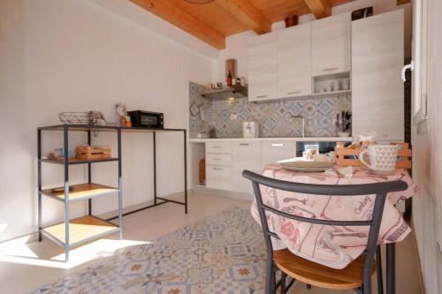 una pequeña cocina con mesa y silla en TS ROOMS - Guest House Sciola, en San Sperate