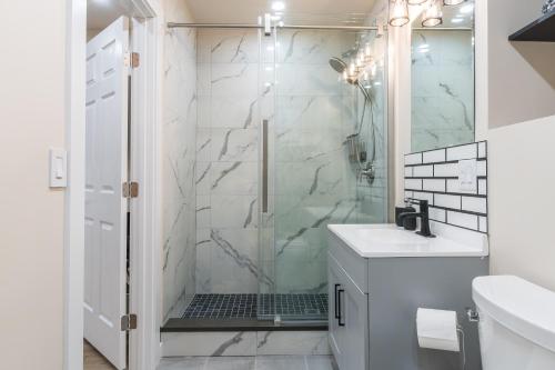 uma casa de banho com um chuveiro e um lavatório branco em Beautiful place with a great location, free parking, WiFi & large TV. em Federal Way