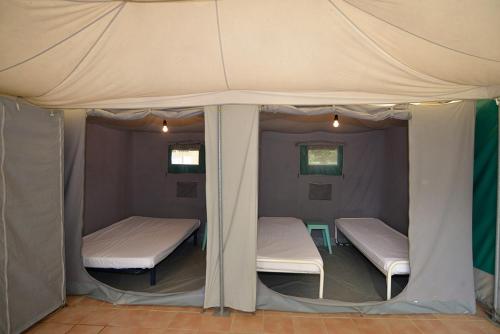 deux lits dans une tente dans une chambre dans l'établissement Camping la Rouviere les Pins, à Vagnas