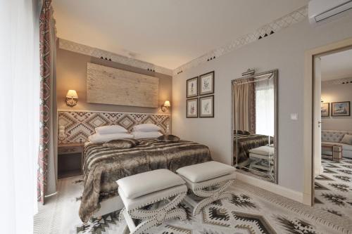 a bedroom with a large bed and a mirror at Aries Hotel & SPA Szczyrk in Szczyrk