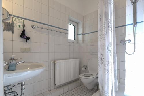 a white bathroom with a sink and a toilet at Haus am Walde in Bad Fallingbostel