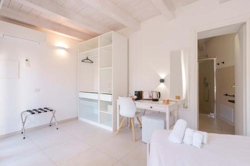a white bedroom with a desk and a bed at Guest House Sciola - TS ROOMS B&B in San Sperate
