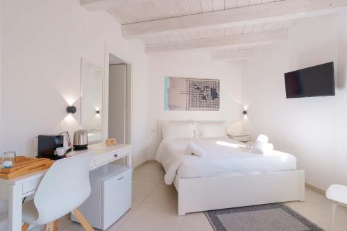 Habitación blanca con escritorio y cama en TS ROOMS - Guest House Sciola, en San Sperate