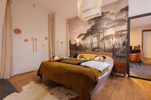 a bedroom with a bed with a painting on the wall at La suite du 21 - jacuzzi - sauna - centre ville in Bourg-en-Bresse