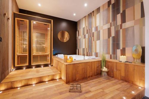 a bathroom with a bath tub and a tub at La suite du 21 - jacuzzi - sauna - centre ville in Bourg-en-Bresse
