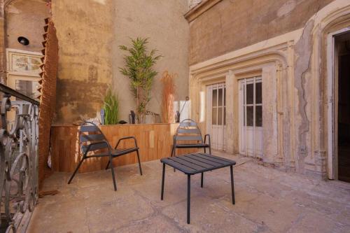 two chairs and a table in an empty room at La suite du 21 - jacuzzi - sauna - centre ville in Bourg-en-Bresse