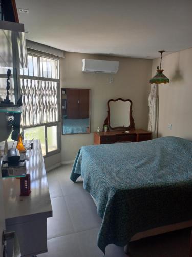 een slaapkamer met een blauw bed en een spiegel bij Apartamento 2 quartos 200 m da praia in Lauro de Freitas