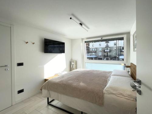 ein Schlafzimmer mit einem großen Bett und einem Fenster in der Unterkunft Cozy APT town centre, 2BTH and garage in Breuil-Cervinia