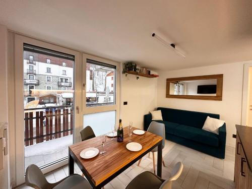 ein Wohnzimmer mit einem Tisch und einem Sofa in der Unterkunft Cozy APT town centre, 2BTH and garage in Breuil-Cervinia