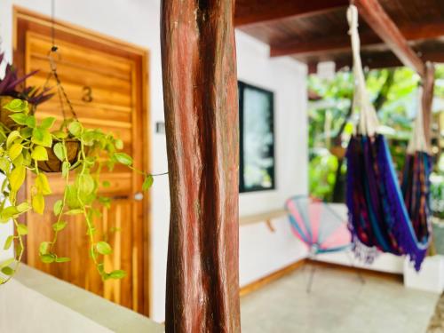 Habitación con puerta de madera y silla en Calipso Ocean Lodge, en Playa Avellana