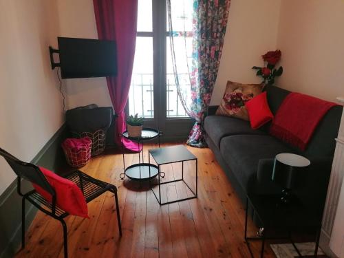 sala de estar con sofá y algunas sillas en Chez Frida en Le Puy-en-Velay