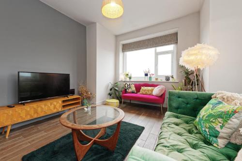 a living room with a couch and a tv at Walpole Bay Sea Views in Margate