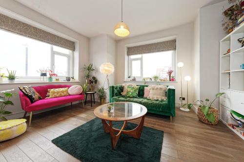 a living room with a green couch and a table at Walpole Bay Sea Views in Margate