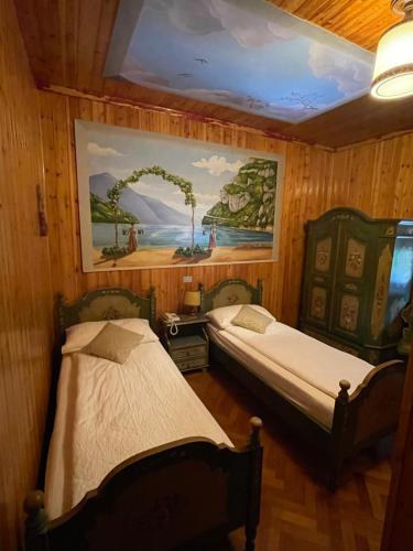 two beds in a room with a painting on the wall at Villaggio Hotel Aquila in Calliano
