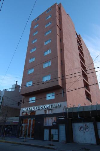 a tall brown building with a sign on it at Hotel El Cortijo in Neuquén