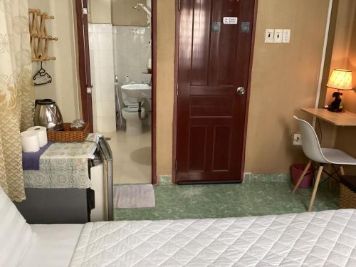 een slaapkamer met een bed en een badkamer met een toilet bij Guest House UTTRANG in Ho Chi Minh-stad
