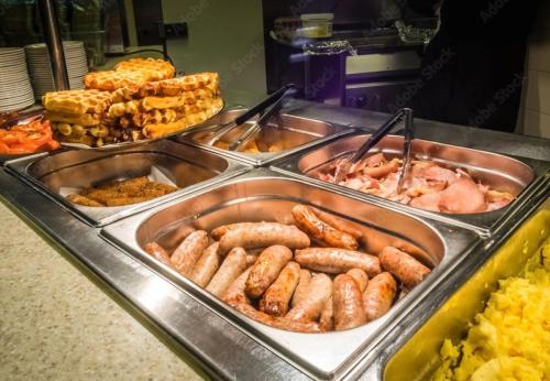 a buffet filled with different types of food in trays at Hilton Garden Inn New York - Times Square Central in New York