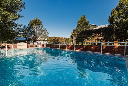 uma grande piscina azul com cerca em Villa de Brome em Lac-Brome