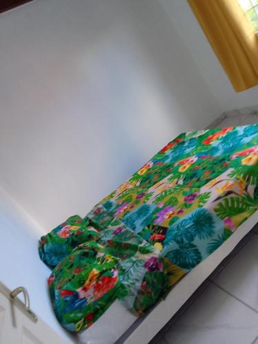 una cama con un edredón colorido encima en EPINAY, en Sainte-Luce