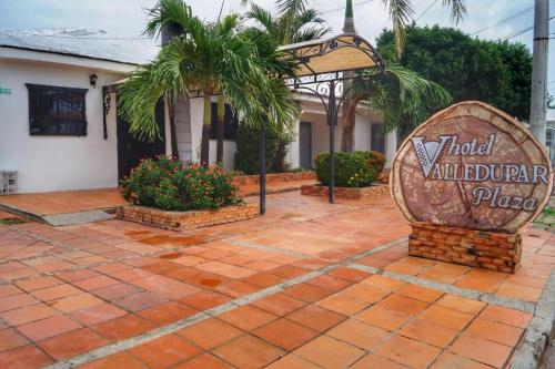 a sign in front of a building with a palm tree at Hotel Valledupar Plaza in Valledupar