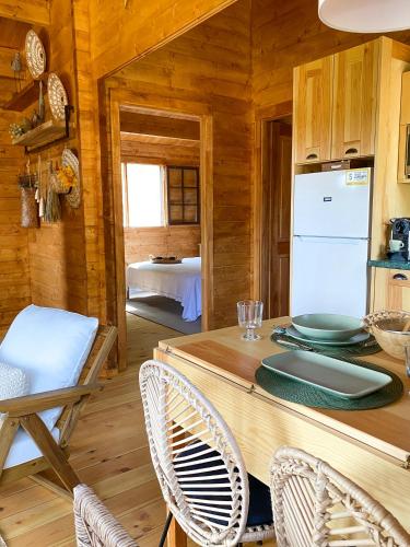 a kitchen with a table and chairs in a cabin at Vale do Laranjal in Setúbal