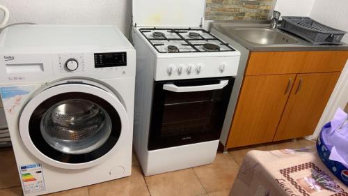 a kitchen with a stove and a washing machine at Nova Montan Azuga in Azuga