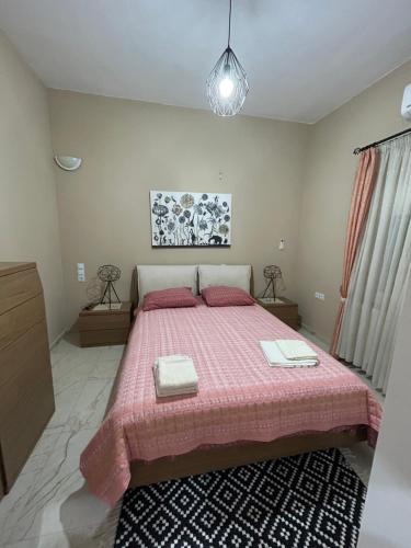 - une chambre avec un grand lit et une couverture rose dans l'établissement Silver House, à Asímion