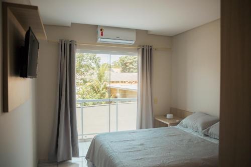 um quarto com uma cama e uma grande janela em Casa com otima localizacao em Foz do Iguacu PR em Foz do Iguaçu