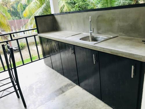 a kitchen with a sink and a balcony at Midira Villa in Galle