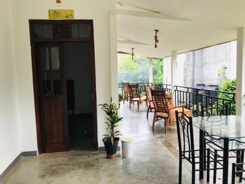 ein Esszimmer mit Stühlen, einem Tisch und einer Tür in der Unterkunft Midira Villa in Galle