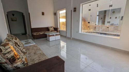 a living room with a couch and a large window at Yasmine Guest House in Luxor