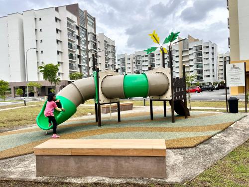 a young girl playing on a slide at a playground at Omak Kito Homestay Melaka in Kampong Alor Gajah