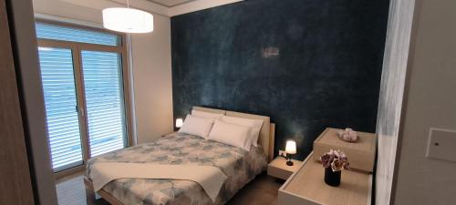 a bedroom with a bed and a black wall at DimoraNOIDUE in Locorotondo