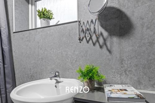 a bathroom sink with a mirror on the wall at Gorgeous 4-bed Home in Nottingham by Renzo, Free Driveway Parking, Sleeps 7! in Beeston