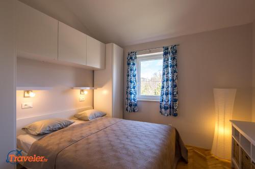 a bedroom with a bed and a window at New villa with swimming pool, olive grove and sea view by Traveler tourist agency Krk ID 2201 in Brzac