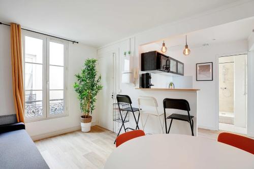 un salon blanc avec une table et des chaises dans l'établissement Modern apartment - 2BR-4P - Sacré-Cœur, à Paris