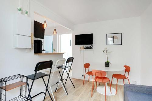 une cuisine et un salon avec une table et des chaises dans l'établissement Modern apartment - 2BR-4P - Sacré-Cœur, à Paris