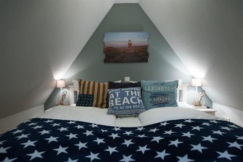 een slaapkamer met een bed met een bedsprei met Amerikaanse vlag bij Robbenloft-Wohnung-11 in Keitum