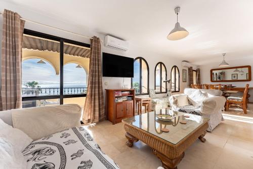 een woonkamer met een bank en een tafel bij Stunning Sea Views Penthouse in La Cala de Mijas