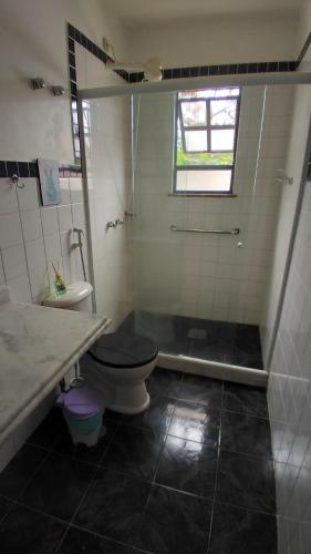 uma casa de banho com um WC, um lavatório e um chuveiro em Condomínio Pousada Amarela 100 metros da Praia em Iguaba Grande