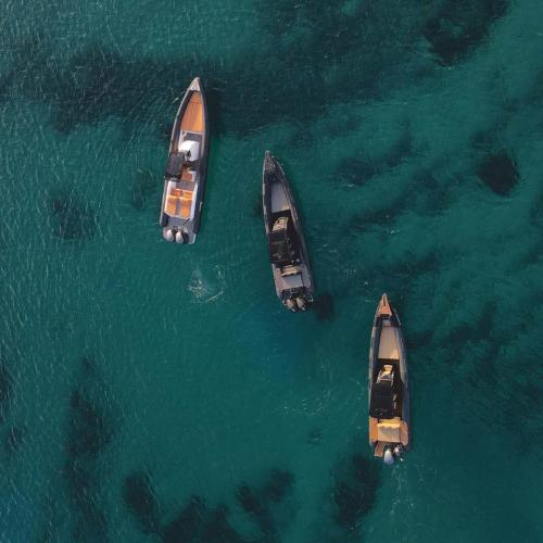 a group of three boats in the water at Elite Power Ribs in Mikonos