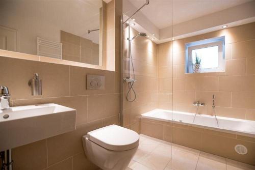 ein Badezimmer mit einem WC, einem Waschbecken und einer Badewanne in der Unterkunft Haus Alster 2 in Westerland