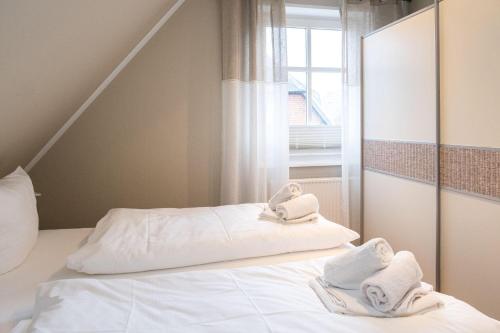 a bedroom with two towels on a bed with a mirror at Haus-Gotland-Wohnung-10 in Westerland