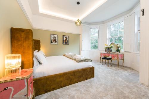 - une chambre avec un grand lit et une table dans l'établissement The West Wing at Hillthorpe Manor by Maison Parfaite - Large 5 Bedroom House with Gardens, à East Hardwick