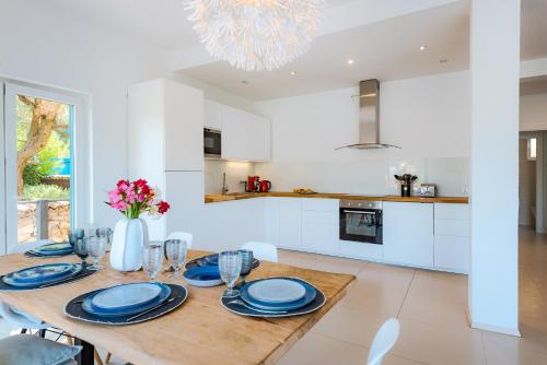 a kitchen and dining room with a table with blue plates at Marceline in Prvić Luka