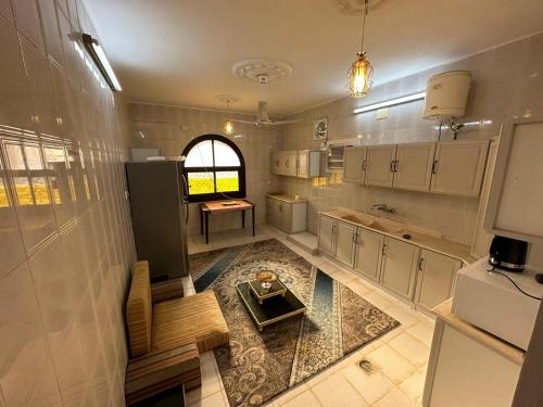 a large kitchen with white cabinets and a table in it at شقة مؤثثة , 10د بالسيارة و 20د مشياً للحرم in Al Madinah