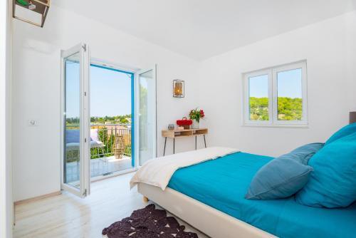 a bedroom with a bed and a balcony at Marceline in Prvić Luka