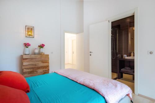a bedroom with a blue bed and a bathroom at Marceline in Prvić Luka