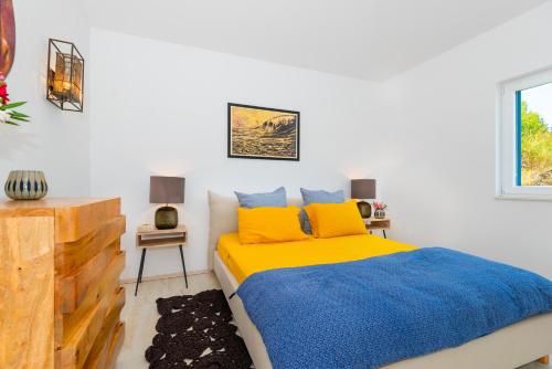 a bedroom with a bed with yellow and blue sheets at Marceline in Prvić Luka